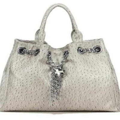 The Nicole Concealed Carry Tote in Synthetic Leather comes in light gray with two handles, silver chain accents, and a decorative front lock.